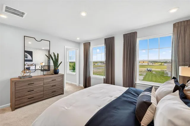 a bedroom with a bed and a large window