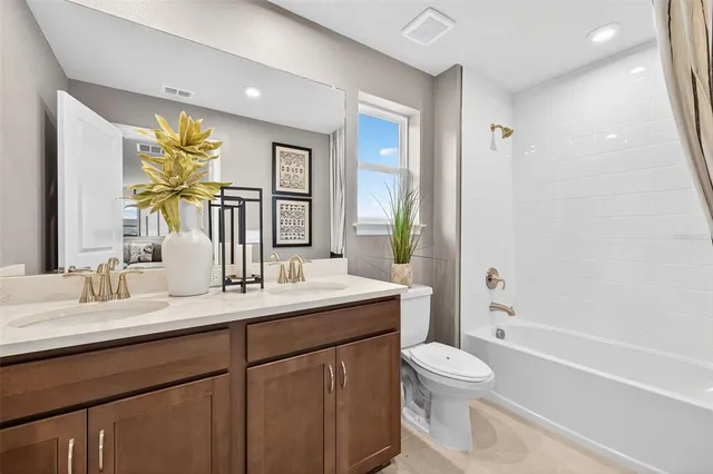 a bathroom with a double vanity sink toilet and shower
