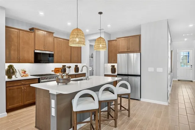 a kitchen with sink a refrigerator and chairs