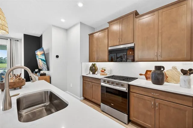 a kitchen with granite countertop a stove sink and cabinets