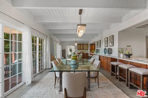 a view of a dining room with furniture a chandelier and wooden floor