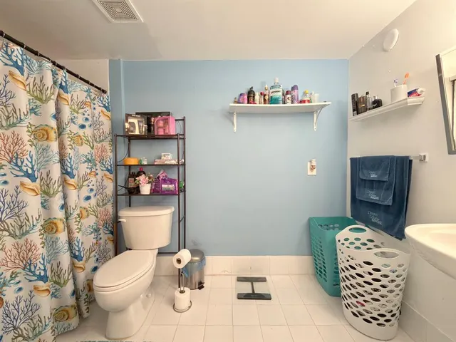 a bathroom with a toilet a sink and a shower curtain