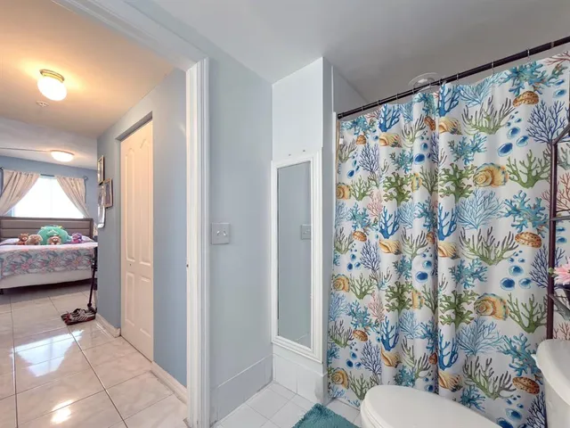 a bathroom with a toilet and a shower curtain