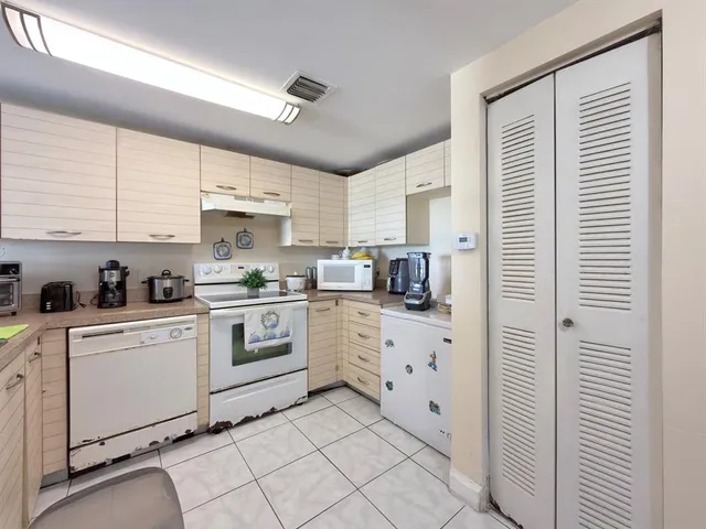 a kitchen with white cabinets and white appliances