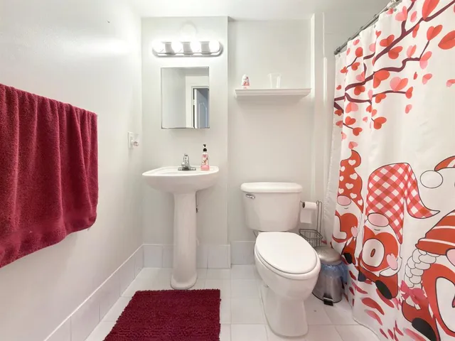 a white toilet sitting next to a bathroom sink and a shower