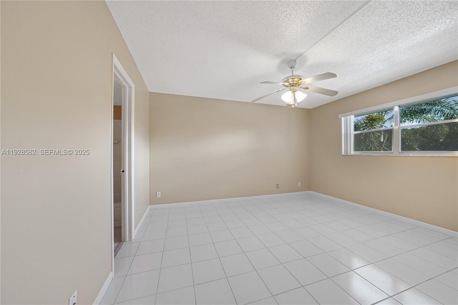 8305 Northwest 61st Street, Unit C305 Tamarac, FL 33321 - Photo 14 of 24 an empty room with chandelier fan and windows