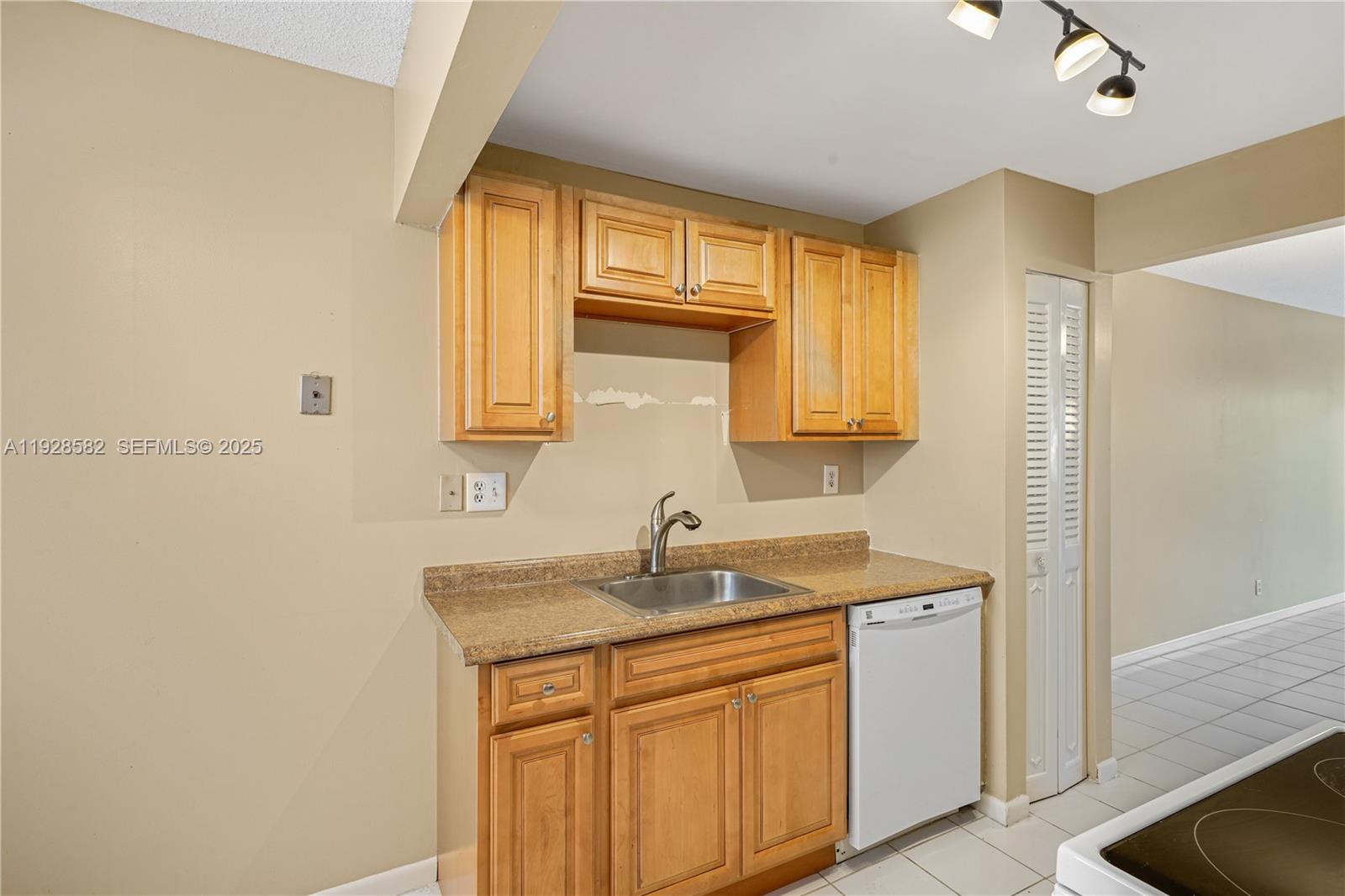 8305 Northwest 61st Street, Unit C305 Tamarac, FL 33321 - Photo 8 of 24 a kitchen with a sink cabinets and a window