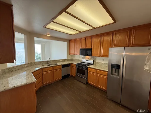a open kitchen with stainless steel appliances granite countertop a stove refrigerator and cabinets