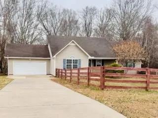 a view of a house with a yard covered by trees