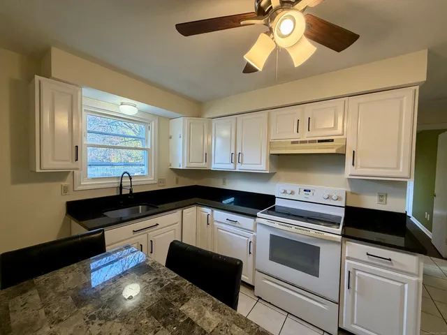 a kitchen with stainless steel appliances a stove a sink and cabinets