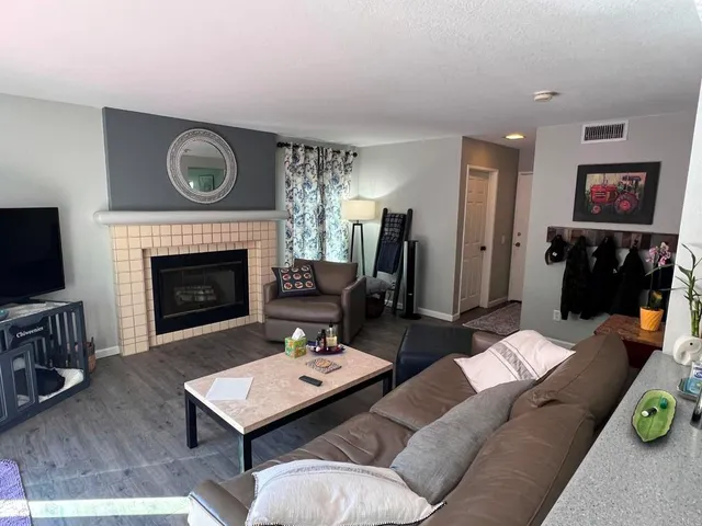 a living room with furniture a fireplace and flat screen tv