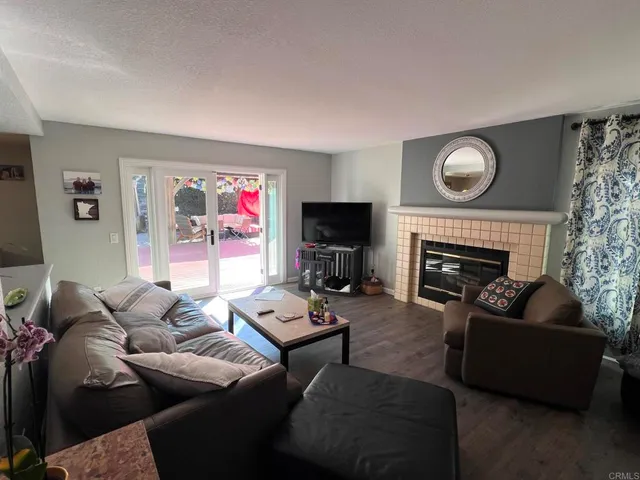 a living room with furniture a fireplace and a flat screen tv
