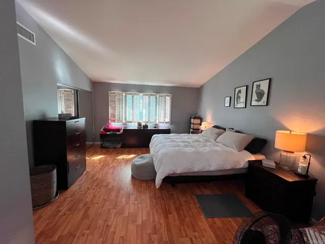 a bedroom with a bed and wooden floor