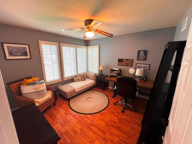 a living room with furniture a flat screen tv and a window