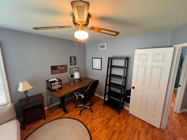 a view of a workspace with furniture and wooden floor