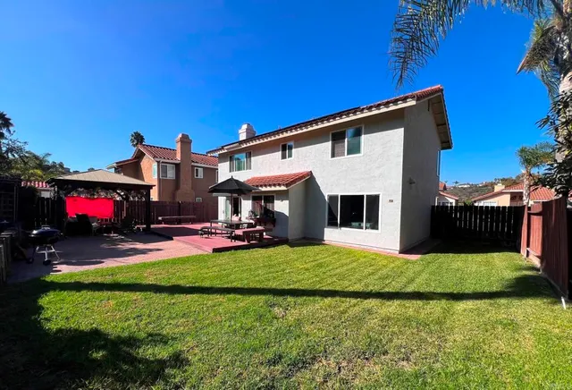 a view of a house with a yard and sitting area