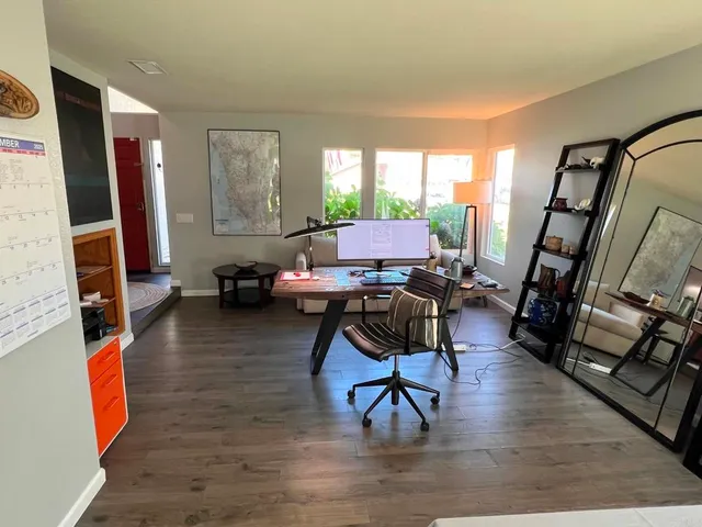 a workspace with wooden floor and furniture