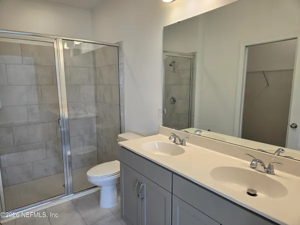 a bathroom with a sink toilet a mirror and shower
