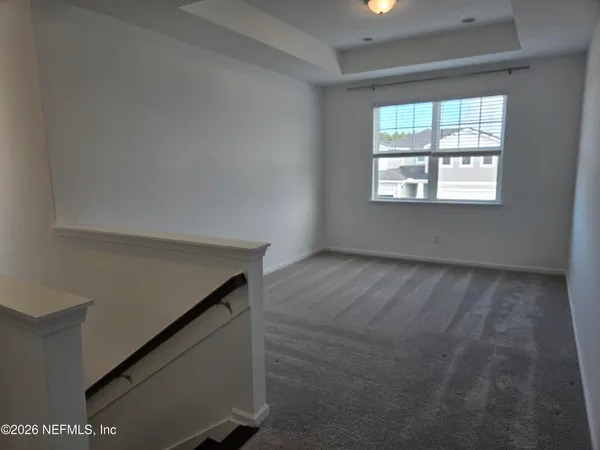 a view of an empty room with closet and a window