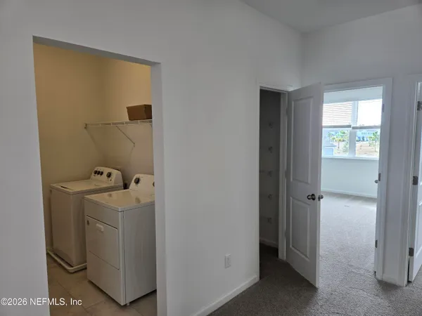 a view of an empty room with closet and a window