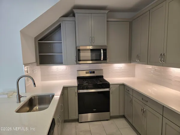 a kitchen with granite countertop a stove and a sink