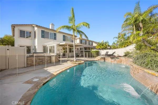 a view of a house with pool and a yard