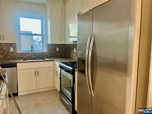 a kitchen with a refrigerator sink and cabinets