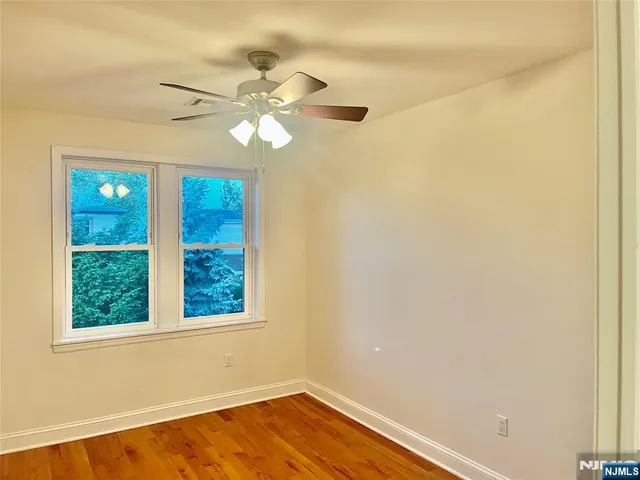 an empty room with a window and a fan