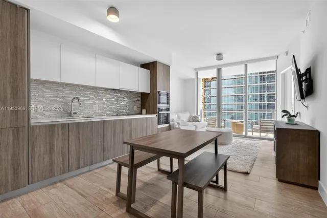a kitchen with a table chairs refrigerator and cabinets