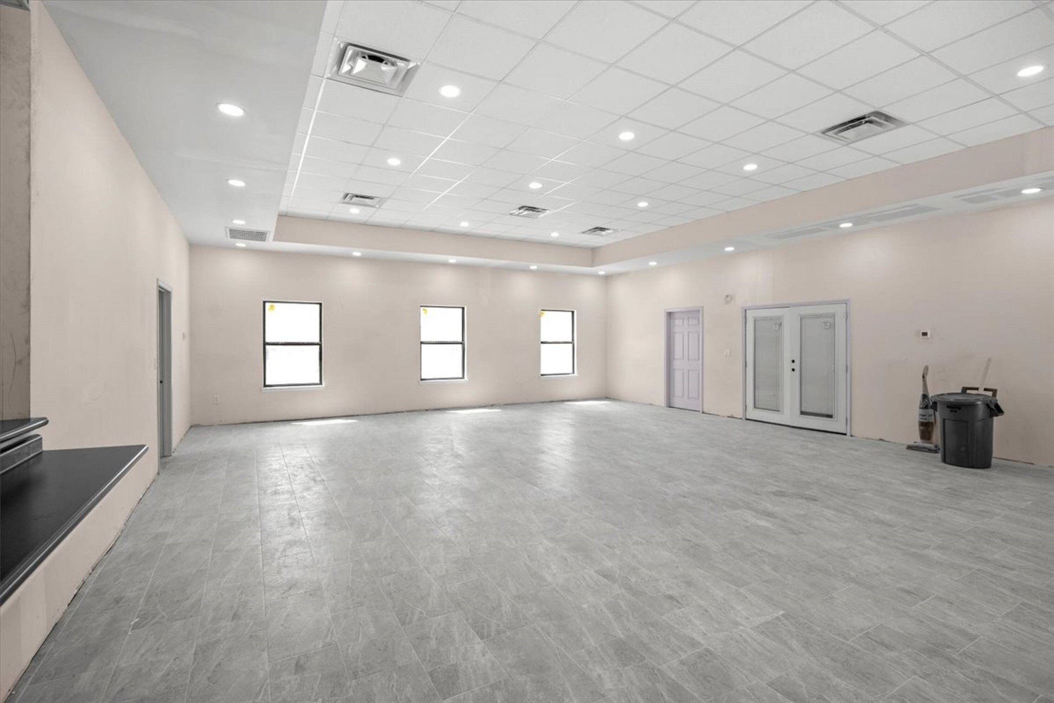 375 King Rea Spur Georgetown, TX 78633 - Photo 13 of 29 Spacious open area featuring light gray tile flooring, multiple windows, recessed lighting, and a drop ceiling