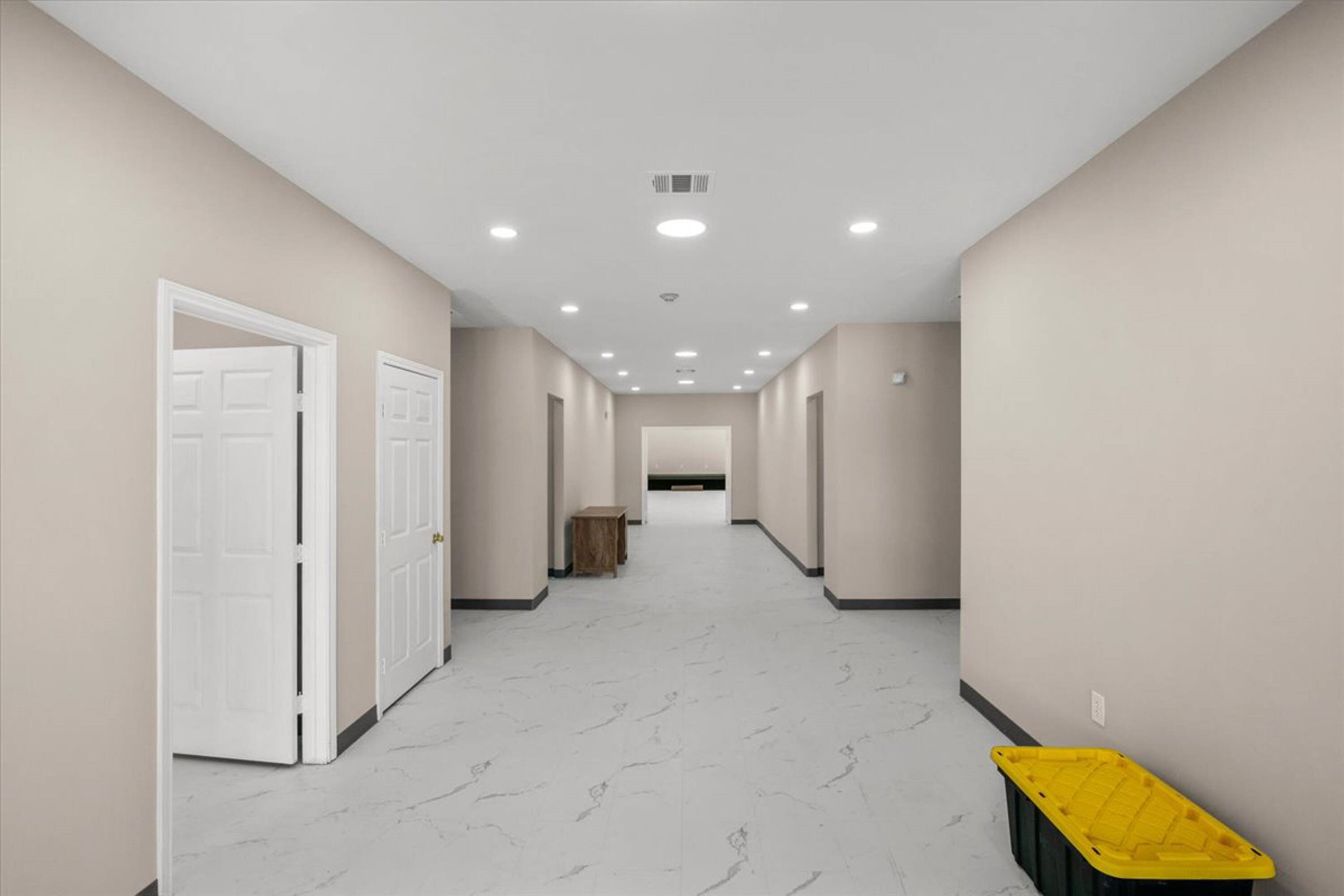 375 King Rea Spur Georgetown, TX 78633 - Photo 20 of 29 Spacious corridor featuring light-toned walls, white tile flooring with subtle veining, recessed lighting, and multiple paneled doors