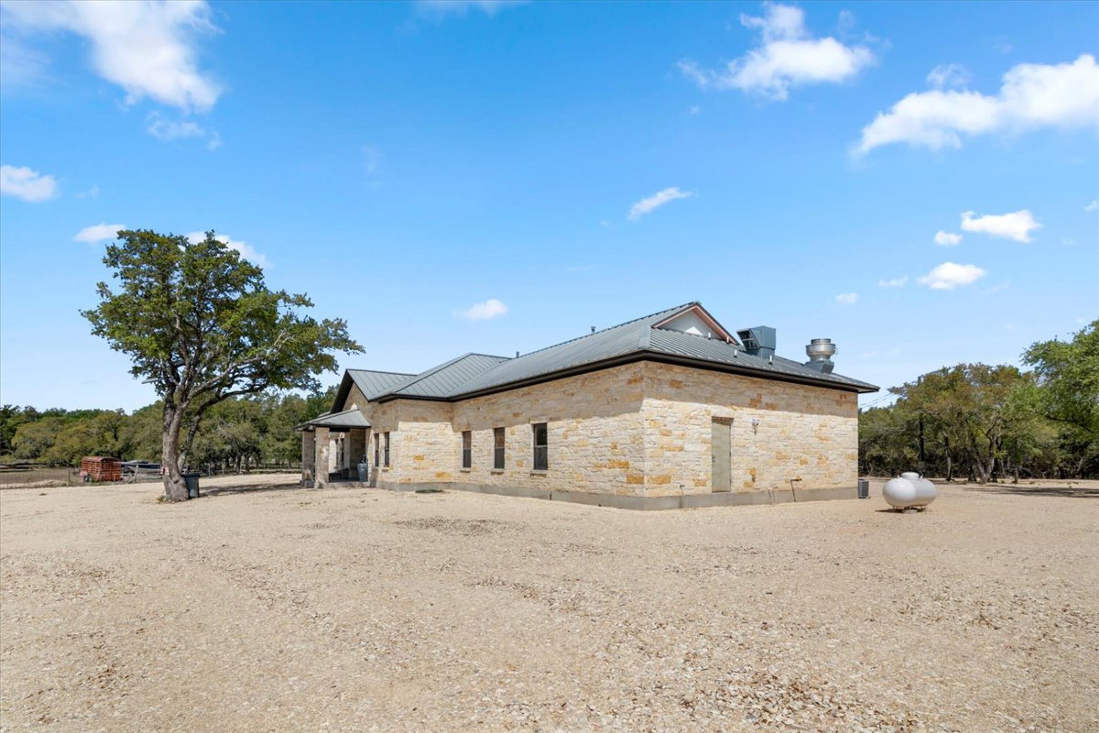 375 King Rea Spur Georgetown, TX 78633 - Photo 23 of 29 Single-story stone exterior structure featuring a dark metal roof