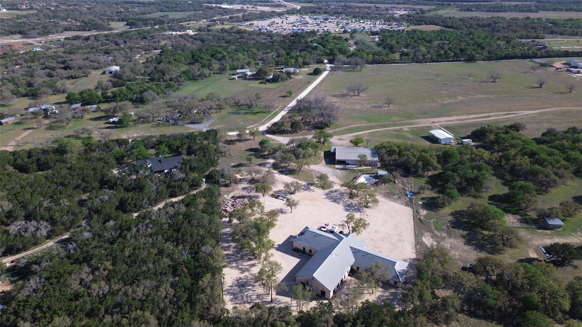 375 King Rea Spur Georgetown, TX 78633 - Photo 3 of 29 Expansive property featuring a large residence with a light-colored roof, surrounded by extensive natural landscaping