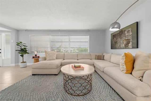 a living room with furniture a fireplace and a large window