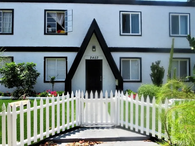 a front view of white house with a garden
