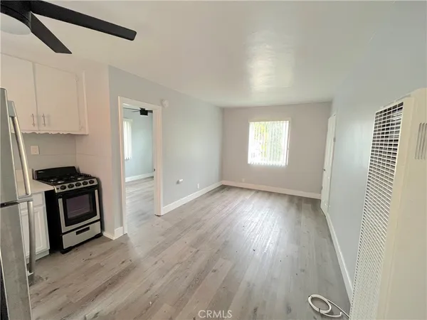 a view of a kitchen with wooden floor and electronic appliances