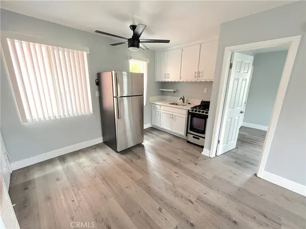 a kitchen with stainless steel appliances a refrigerator a stove a sink and a window