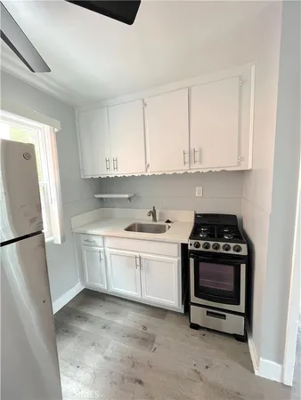 a kitchen with stainless steel appliances granite countertop a stove a refrigerator and a white cabinets