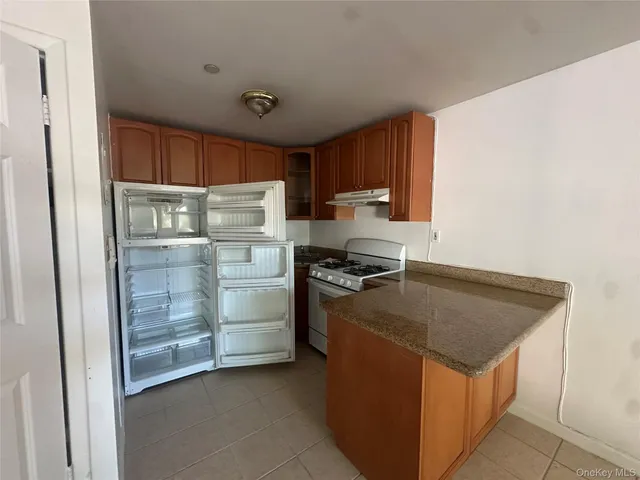 a kitchen with stainless steel appliances granite countertop a stove a refrigerator and a refrigerator