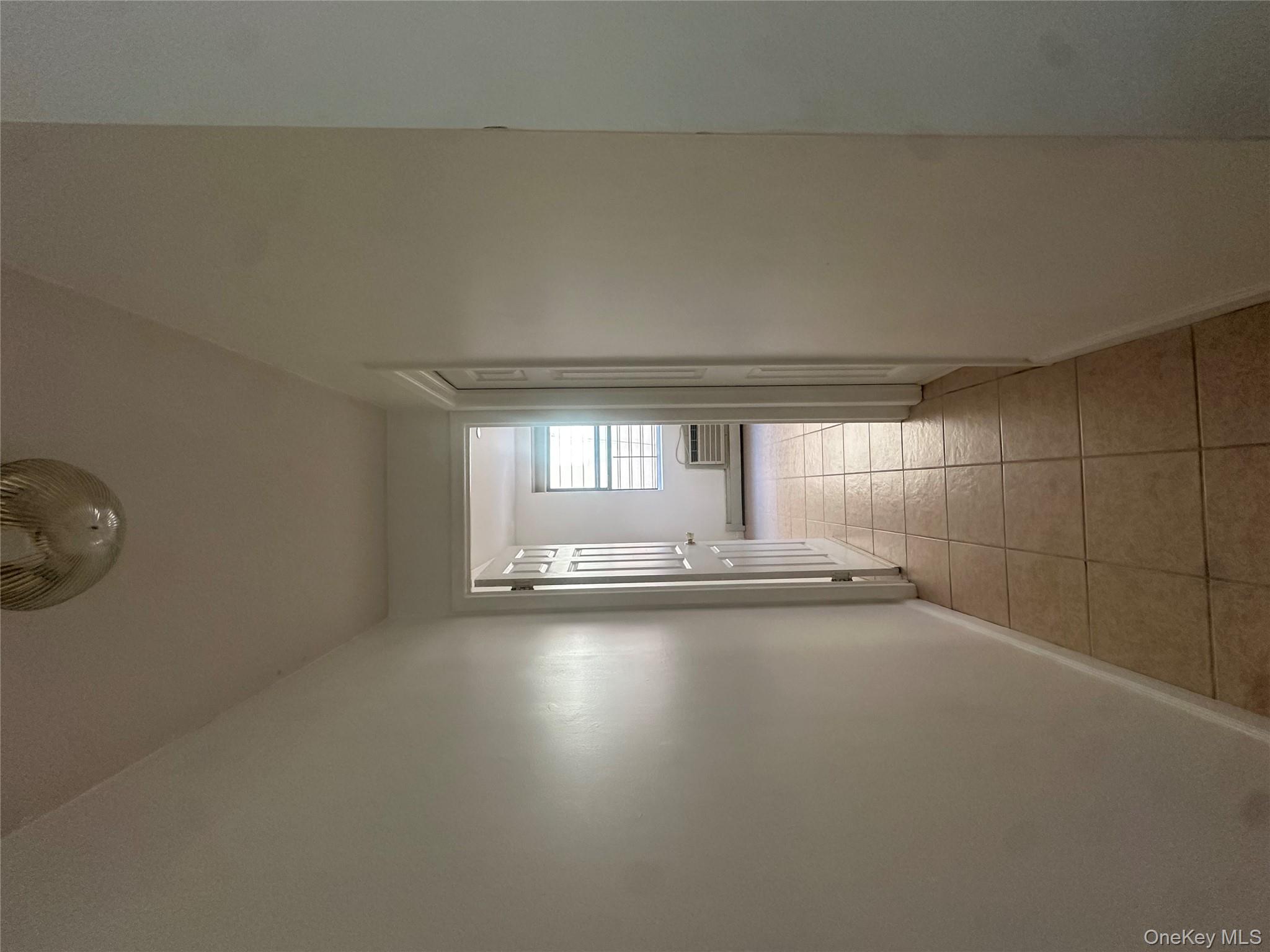 40-35 95th Street, Unit 2A Queens, NY 11373 - Photo 5 of 11 a view of a hallway with wooden floor and a bathroom