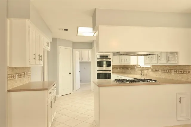 a kitchen with stainless steel appliances granite countertop a sink and a stove