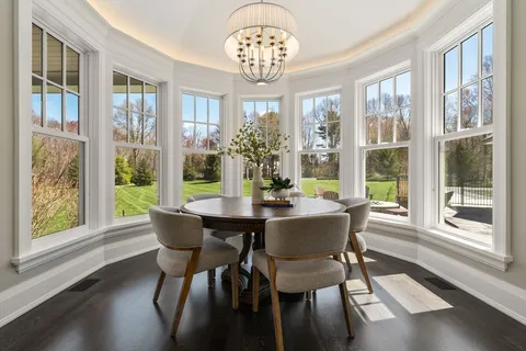 a view of a dining room with furniture a chandelier and wooden floor