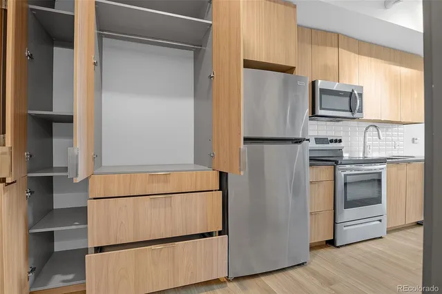 a white refrigerator freezer and a stove sitting inside of a kitchen