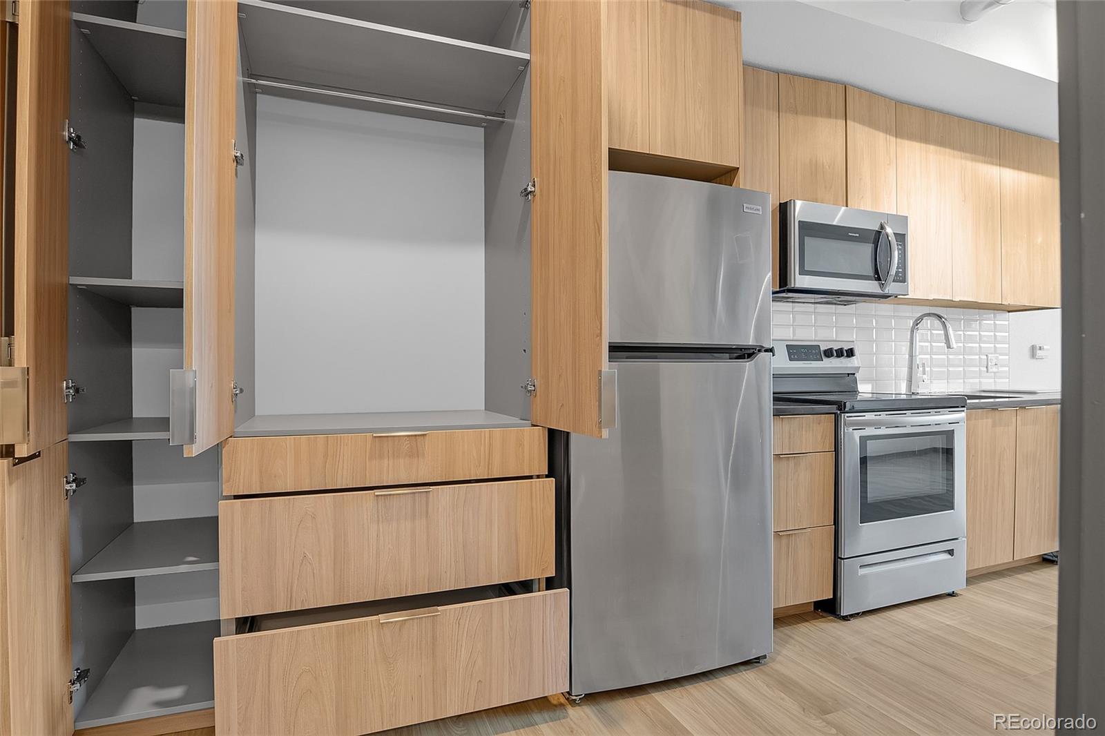 603 Inca Street, Unit 303 Denver, CO 80204 - Photo 5 of 15 a white refrigerator freezer and a stove sitting inside of a kitchen