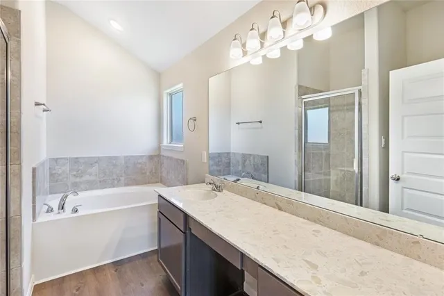 a bathroom with a granite countertop sink a large mirror and a bathtub