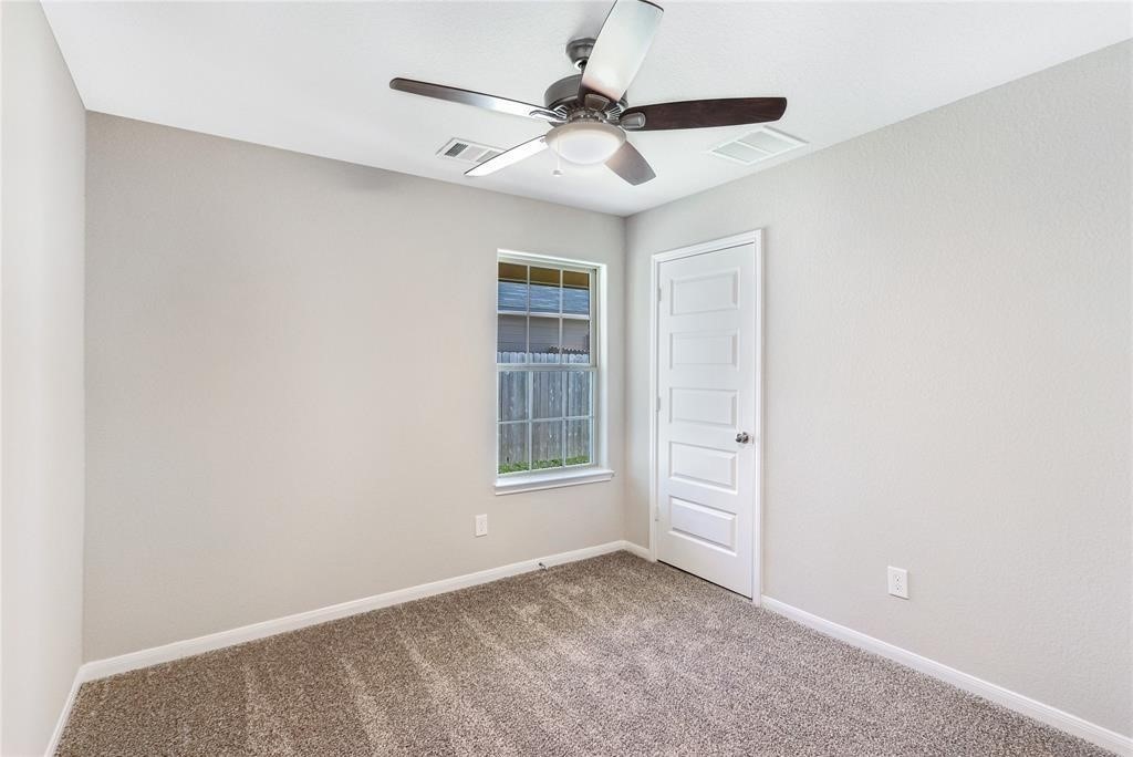 1821 Hidden Cedar Court Conroe, TX 77301 - Photo 7 of 10 an empty room with windows and fan