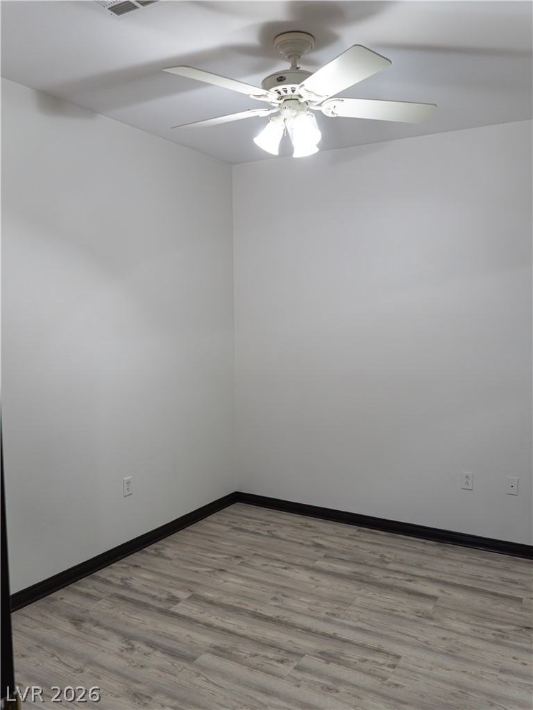 1466 Orange Jubilee Road Henderson, NV 89014 - Photo 8 of 15 A quiet room featuring wood-look flooring and a functional ceiling fan for optimal air circulation.