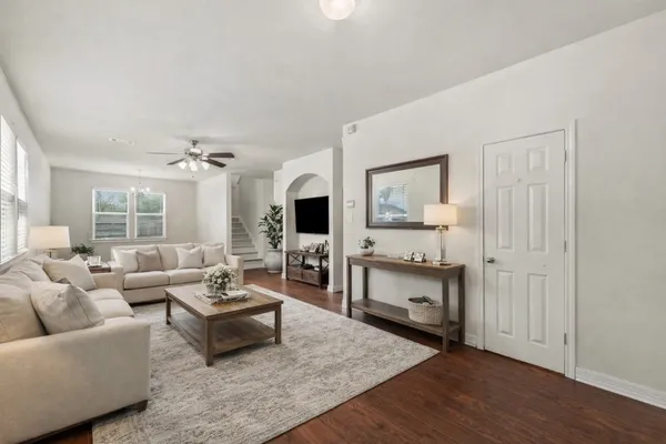 a living room with furniture and a wooden floor