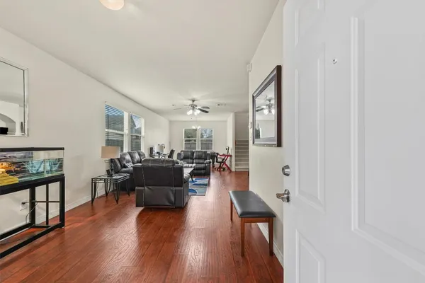 a living room with furniture and a wooden floor