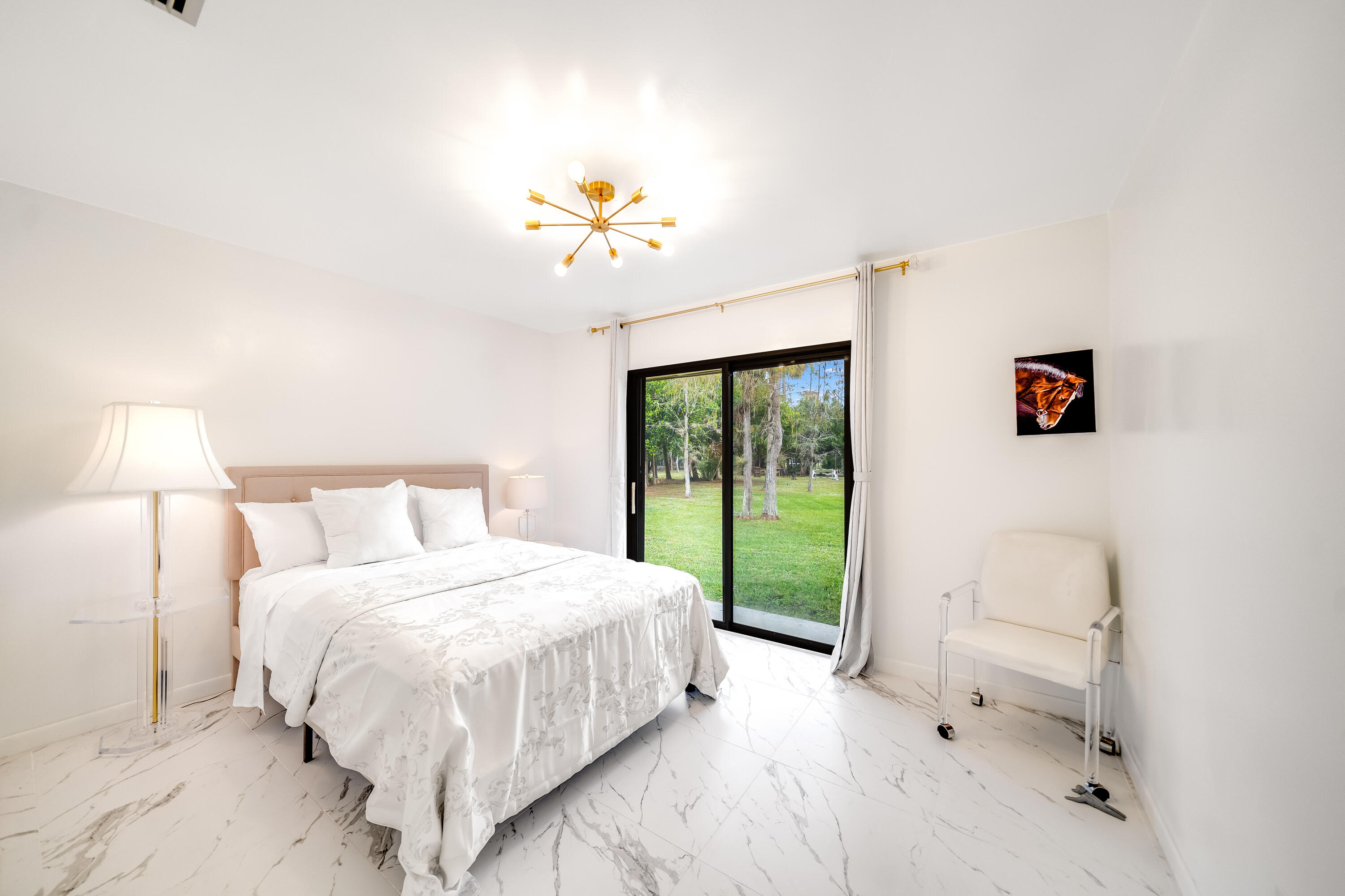 583 Rambling Dr Circle Wellington, FL 33414 - Photo 16 of 40 a bedroom with a bed and a chandelier